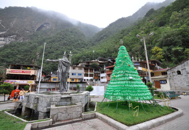 Plaza de Aguas Calientes con estatua de Pachacútec y montañas al fondo